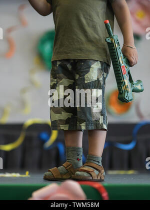 Plus de détails avec le soldat tenue d'un petit garçon, sur scène lors d'une célébration de la prom de la maternelle. Banque D'Images