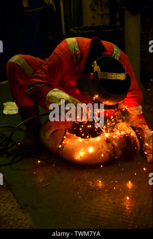 Soudeur et son assistant fabriquer dans un atelier de tuyauterie avec porter un équipement de protection complet Banque D'Images