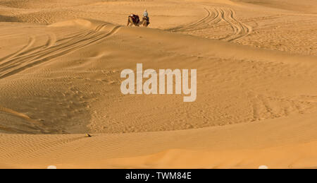 Propriétaire d'un chameau est à la recherche d'un client dans les dunes de sable de Sam, Jaisalmer, Rajasthan, Inde.Ils prennent les gens pour safari dans le désert qui est une grande expérience. Banque D'Images