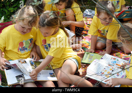 18 juin 2019, la Saxe-Anhalt, Mücheln-Stöbnitz : Après le déjeuner, les enfants du groupe ant du jardin d'aventure 'Rainbow' dans Mücheln-Stöbnitz avec leur éducateur Jennifer Geheb regarder des livres à leurs petits abris fortifiés à la tour d'observation Geiseltalsee. Tous les jours jusqu'à 12 enfants d'âge pré-scolaire et leurs enseignants d'explorer la nature et de l'richement boisée, non loin du plus grand lac artificiel d'Allemagne. Le concept pédagogique est basé sur une proximité de la nature et de l'apprentissage expérientiel. Photo : Waltraud Grubitzsch/dpa-Zentralbild/ZB Banque D'Images