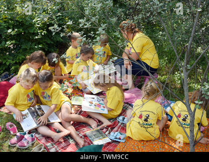 18 juin 2019, la Saxe-Anhalt, Mücheln-Stöbnitz : Après le déjeuner, les enfants du groupe ant du jardin d'aventure 'Rainbow' dans Mücheln-Stöbnitz avec leur éducateur Jennifer Geheb regarder des livres à leurs petits abris fortifiés à la tour d'observation Geiseltalsee. Tous les jours jusqu'à 12 enfants d'âge pré-scolaire et leurs enseignants d'explorer la nature et de l'richement boisée, non loin du plus grand lac artificiel d'Allemagne. Le concept pédagogique est basé sur une proximité de la nature et de l'apprentissage expérientiel. Photo : Waltraud Grubitzsch/dpa-Zentralbild/ZB Banque D'Images