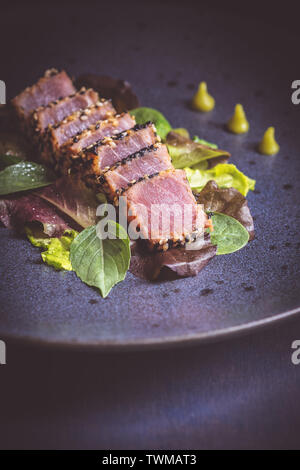 Steak de thon grillé avec salade et sauce wasabi chaud Banque D'Images