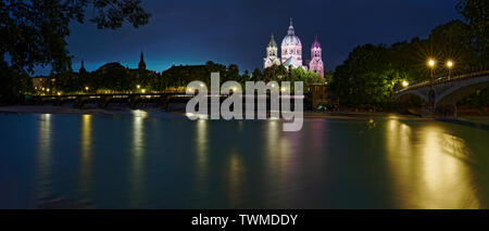 L'exposition longue nuit grand angle de l'Isar Wehrsteg avec un pont sur la droite et de l'église Sankt Lukas en arrière-plan. Banque D'Images