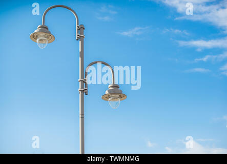 Un lampadaire double typique sur un fond de ciel bleu. Banque D'Images