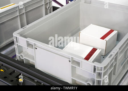 Caisses en plastique à rouleaux de transport dans la production en usine ou l'entrepôt et le tri Banque D'Images