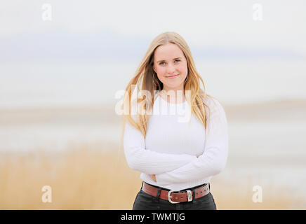 Jeune femme avec de longs cheveux blonds se dresse en face avec confiance du Grand Lac Salé. Banque D'Images