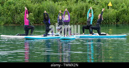 Upminster, Essex, Royaume-Uni. 21 juin 2019. Une nouvelle initiative de mieux-être a été lancée aujourd'hui par Yogactive : Stand up Paddleboard vinyasa yoga tenue au Centre d'Aventure Stubbers Upminster Crédit Essex Ian Davidson/Alamy Live News Banque D'Images