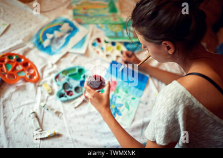 Jeune femme profiter en peinture avec verre de vigne Banque D'Images