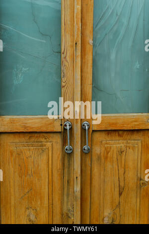 Vieille porte en bois brun avec poignées en métal. photo verticale porte. dans la rue dans l'ancienne maison Banque D'Images