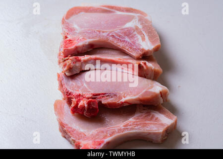 La viande steak de porc cru juteux prêt pour grill. Focus sélectif. La viande avec les oignons, le poivre, sel et épices. Banque D'Images