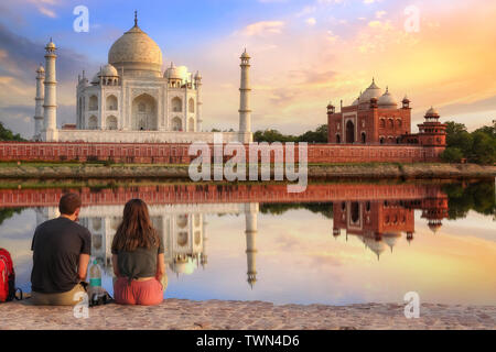 Taj Mahal coucher du soleil vue depuis Mehtab Bagh sur les bords de la rivière Yamuna avec un couple de touristes appréciant un moment romantique. Banque D'Images