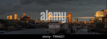 Londres, Angleterre. 21 juin, 2019. Le soleil illumine le Tower Bridge comme navire de croisière vent argent moors à côté de HMS Belfast sur la Tamise à Londres. Banque D'Images