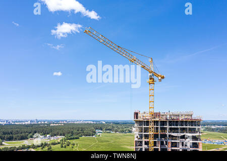 Travailler sur la grue en construction highrise residential building contre paysage urbain Banque D'Images