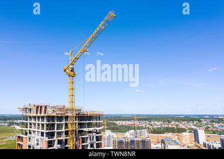 Location vacances construction. grue jaune près du bâtiment contre le ciel bleu Banque D'Images