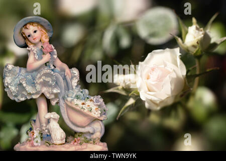 Figurine Vintage Girl wearing bunny jupon avec une rose blanche et crémeuse sur fond vert. Composition Banque D'Images