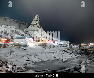 Village de pêcheurs sur la montagne de neige du glacier avec la nuit. Îles Lofoten Banque D'Images