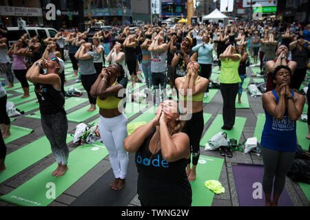 New York, USA. 21 Juin, 2019. Les gens participent à une classe de yoga à Solstice au cours de Times Square à New York, États-Unis, 21 juin 2019. Tous les jours de l'événement célébré yoga l'hémisphère nord est plus longue journée de l'année et le début de la saison estivale. Crédit : Michael Nagle/Xinhua/Alamy Live News Banque D'Images