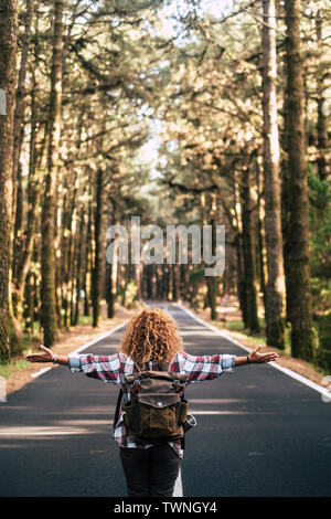 D'autres concept avec curly hipster femme vu de dos ouvrir ses bras et de sentir la liberté de l'extérieur, debout au milieu de la nature Banque D'Images