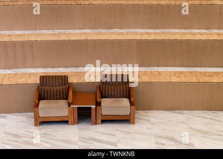 Des chaises en bois avec matelas sur fond d'escalier Banque D'Images
