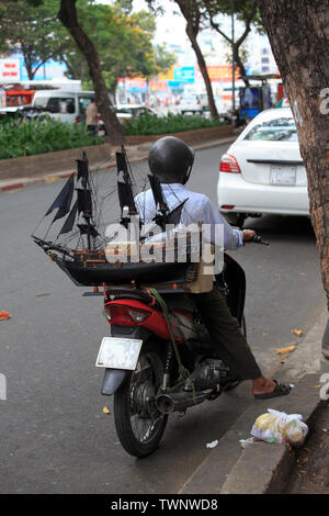 Ho Chi Minh, Vietnam - 21 Avril 2014 : l'homme vietnamiens prépare le transport d'un modèle de navire sur une moto Banque D'Images