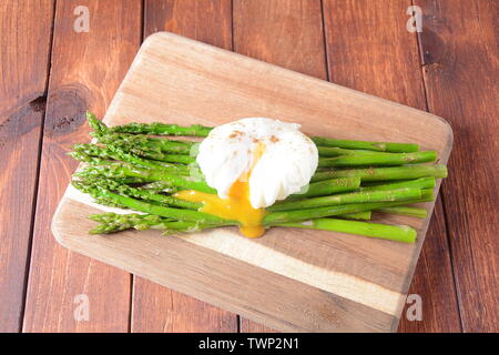 Œufs pochés avec asperges frits, fromage à la crème, le saumon et les épices sur un toast. Œufs pochés avec fuite.Petit-déjeuner français sain concept Banque D'Images