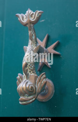 Poignée de porte ancienne dolphin avec croix de Malte sur la porte verte, La Valette, Malte. Banque D'Images