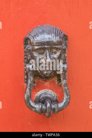 Poignée de porte en bronze décoratifs sous la forme d'une belle tête de la femme sur une porte peinte en jaune. Malte. Banque D'Images