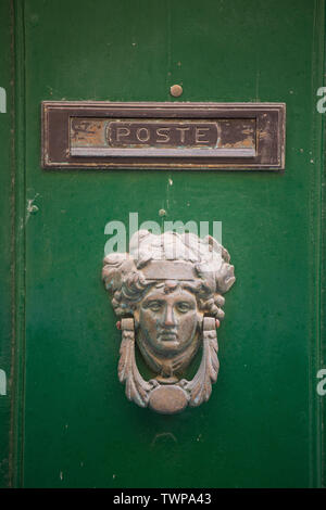 Poignée de porte en bronze décoratifs sous la forme d'une belle tête de la femme sur une porte peinte en jaune. Malte. Banque D'Images