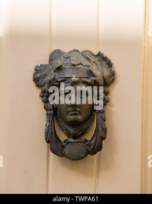 Poignée de porte en bronze décoratifs sous la forme d'une belle tête de la femme sur une porte peinte en jaune. Malte. Banque D'Images