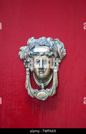 Poignée de porte en bronze décoratifs sous la forme d'une belle tête de la femme sur une porte peinte en jaune. Malte. Banque D'Images