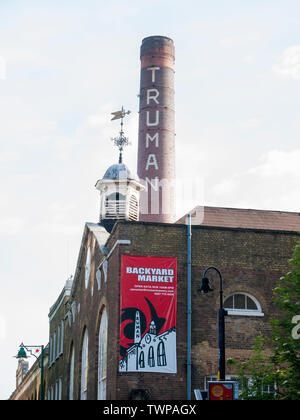 Brick Lane en regardant vers le repère de la cheminée de la brasserie historique de l'Aigle Noir connu sous le nom de Truman Brewery Banque D'Images