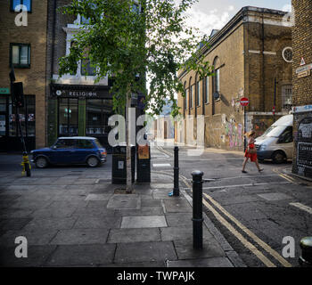 Coin de Brick Lane et Quaker Street à côté de la Truman Brewery, tôt le matin et la circulation des piétons sur leur façon de travailler Banque D'Images