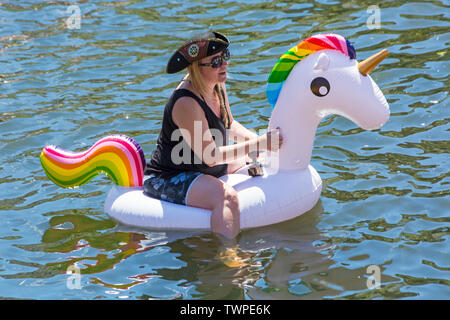 Iford, Dorset, UK. 22 juin 2019. Un temps magnifique, ensoleillé et chaud, toujours pour Dorset Canot Journée avec des centaines de jeux gonflables, des dériveurs, artisanat, conseils formant une flottille, de mettre les voiles de l'IFORD pont rivière Stour de Tuckton bridge. L'événement a commencé en 2014 comme un petit peu de plaisir, mais est maintenant devenu un événement annuel recueillant des fonds pour des organismes de bienfaisance et fonceur plus grand chaque année. Woman having fun sur unicorn gonflable gonflable. Credit : Carolyn Jenkins/Alamy Live News Banque D'Images