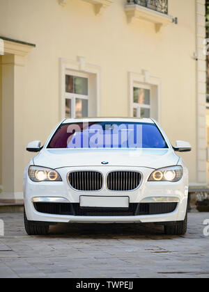 Minsk, Bélarus, 16 mai 2013 : le luxe moderne BMW 750Li XDrive voiture Vue de face en stationnement sur parking pavée près de la maison ancienne à la verticale. Banque D'Images