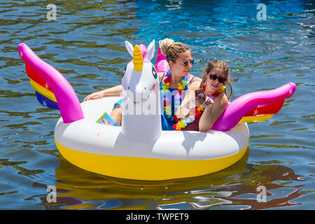 Iford, Dorset, UK. 22 juin 2019. Un temps magnifique, ensoleillé et chaud, toujours pour Dorset Canot Journée avec des centaines de jeux gonflables, des dériveurs, artisanat, conseils formant une flottille, de mettre les voiles de l'IFORD pont rivière Stour de Tuckton bridge. L'événement a commencé en 2014 comme un petit peu de plaisir, mais est maintenant devenu un événement annuel recueillant des fonds pour des organismes de bienfaisance et fonceur plus grand chaque année. Les femmes s'amusant sur unicorn gonflable gonflable. Credit : Carolyn Jenkins/Alamy Live News Banque D'Images