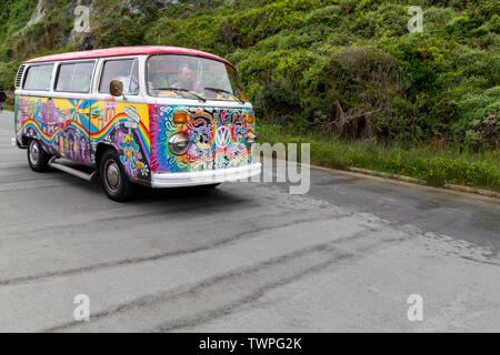 Van Volkswagen peints dans des couleurs vives roulant dans la rue dans la ville de San Francisco Banque D'Images