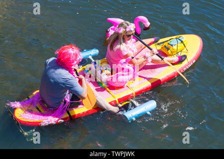 Iford, Dorset, UK. 22 juin 2019. Un temps magnifique, ensoleillé et chaud, toujours pour Dorset Canot Journée avec des centaines de jeux gonflables, des dériveurs, artisanat, conseils formant une flottille, de mettre les voiles de l'IFORD pont rivière Stour de Tuckton bridge. L'événement a commencé en 2014 comme un petit peu de plaisir, mais est maintenant devenu un événement annuel recueillant des fonds pour des organismes de bienfaisance et fonceur plus grand chaque année. L'homme et la femme assis détente sur O'Shea paddleboard gonflables gonflables SUP paddle board. Credit : Carolyn Jenkins/Alamy Live News Banque D'Images