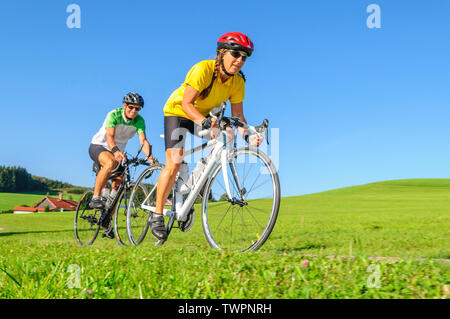 Couple faisant un tour à vélo sur vélo de course à un après-midi ensoleillé de Bavière Allgäu Banque D'Images