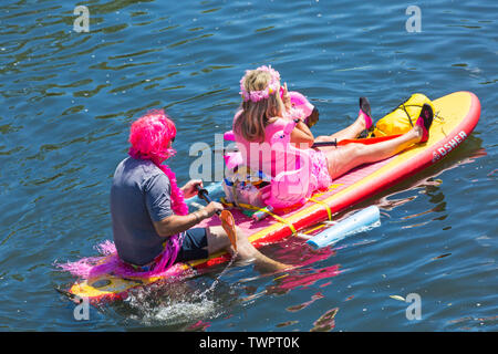 Iford, Dorset, UK. 22 juin 2019. Un temps magnifique, ensoleillé et chaud, toujours pour Dorset Canot Journée avec des centaines de jeux gonflables, des dériveurs, artisanat, conseils formant une flottille, de mettre les voiles de l'IFORD pont rivière Stour de Tuckton bridge. L'événement a commencé en 2014 comme un petit peu de plaisir, mais est maintenant devenu un événement annuel recueillant des fonds pour des organismes de bienfaisance et fonceur plus grand chaque année. L'homme et la femme assis détente sur O'Shea paddleboard gonflables gonflables SUP paddle board. Credit : Carolyn Jenkins/Alamy Live News Banque D'Images