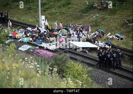 Morschenich, Allemagne. 22 Juin, 2019. Les militants sont de bloquer les voies du chemin de fer de Hambach. Le chemin de fer de Hambach à ciel ouvert est une ligne de chemin de fer de liaison dans le réseau privé d'énergie RWE dans la zone d'exploitation du lignite rhénan. Elle relie le Hambach mine à ciel ouvert au nord-sud, qui alimente les centrales électriques de Niederaußem, Frimmersdorf et Neurath avec le lignite. Credit : Henning Kaiser/dpa/Alamy Live News Banque D'Images