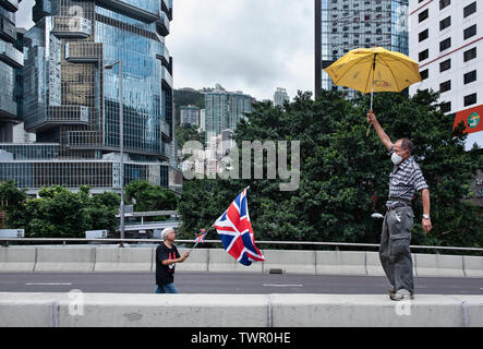 Les vagues un manifestant le Royaume-Uni de Grande-Bretagne et d'Irlande du Nord tandis qu'un autre drapeau est titulaire d'un parapluie jaune, symbole de la circulation, tandis que les routes ont été bloquées. Malgré le chef de la carrie Lam a tenté d'atténuer les tensions en acceptant de suspendre le controversé projet de loi sur l'extradition, des groupes d'étudiants et de l'union a continuer la protestation contre le gouvernement de Hong Kong. Les manifestants ont demandé le retrait de la controversée LOI SUR L'extradition, la libération et la non-poursuite des gens arrêtés en raison de la cause, de savoir si une force excessive Banque D'Images