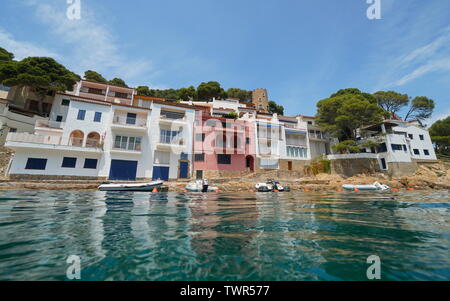 Maisons au bord de l'eau avec des bateaux amarrés dans un village méditerranéen sur la Costa Brava en Espagne, vue depuis la surface de l'eau, Sa Tuna, Begur, Catalogne Banque D'Images