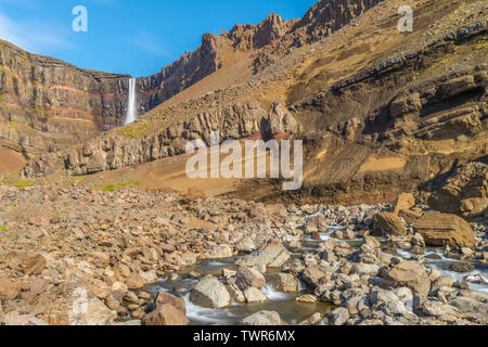 La Hengifoss chute se déversant dans le canyon. Les couches de roches stratifiées, des formations géologiques, vu le long des parois du canyon. Banque D'Images