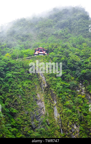 Amazing temple dans le parc national de Taroko taïwanais. Le culte religieux sur un rocher abrupt est entouré de vert tropical forest. Misty, temps brumeux. Concept. De beaux endroits. Voyage de la Chine. Banque D'Images