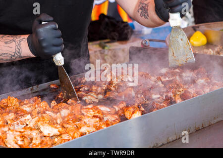 Un homme chef prépare des filets de poulet bbq barbecue cuit Banque D'Images