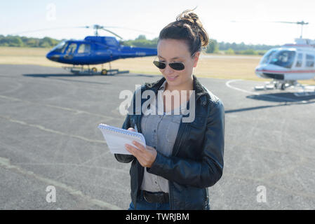 Jeune femme commander billet de visite de l'hélicoptère par tablet Banque D'Images