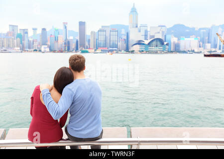 Horizon de Hong Kong et le port de Victoria. Les touristes couple enjoying view et le tourisme sur la promenade de Tsim Sha Tsui et de l'Avenue des Stars à Victoria Harbour, Kowloon, Hong Kong. Concept de l'industrie du tourisme. Banque D'Images