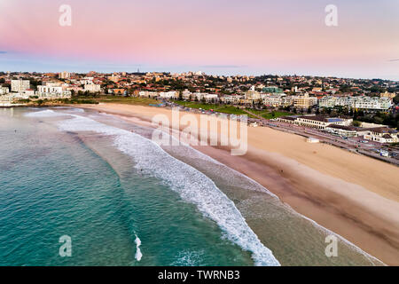 Calme doux des vagues de l'océan Pacifique à terre du matériel roulant de Bondi Beach avec surfers équitation les vagues au début de l'heure avant l'aube. La vie australienne détente à Sydney Banque D'Images