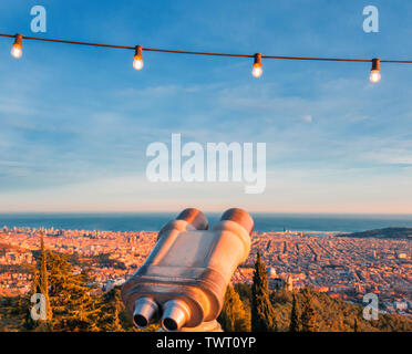 Jumelles télescope touristique pour faire du tourisme avec des lumières allumées au-dessus. Paysage du soir de la ville de la hauteur. Banque D'Images