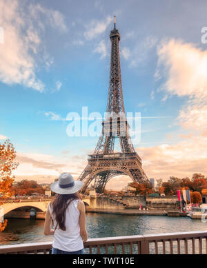 Jeune femme à la vue de la tour Eiffel à Paris en automne Banque D'Images